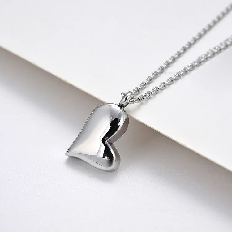 Silver stainless steel necklace with curved peach heart pendant on adjustable chain