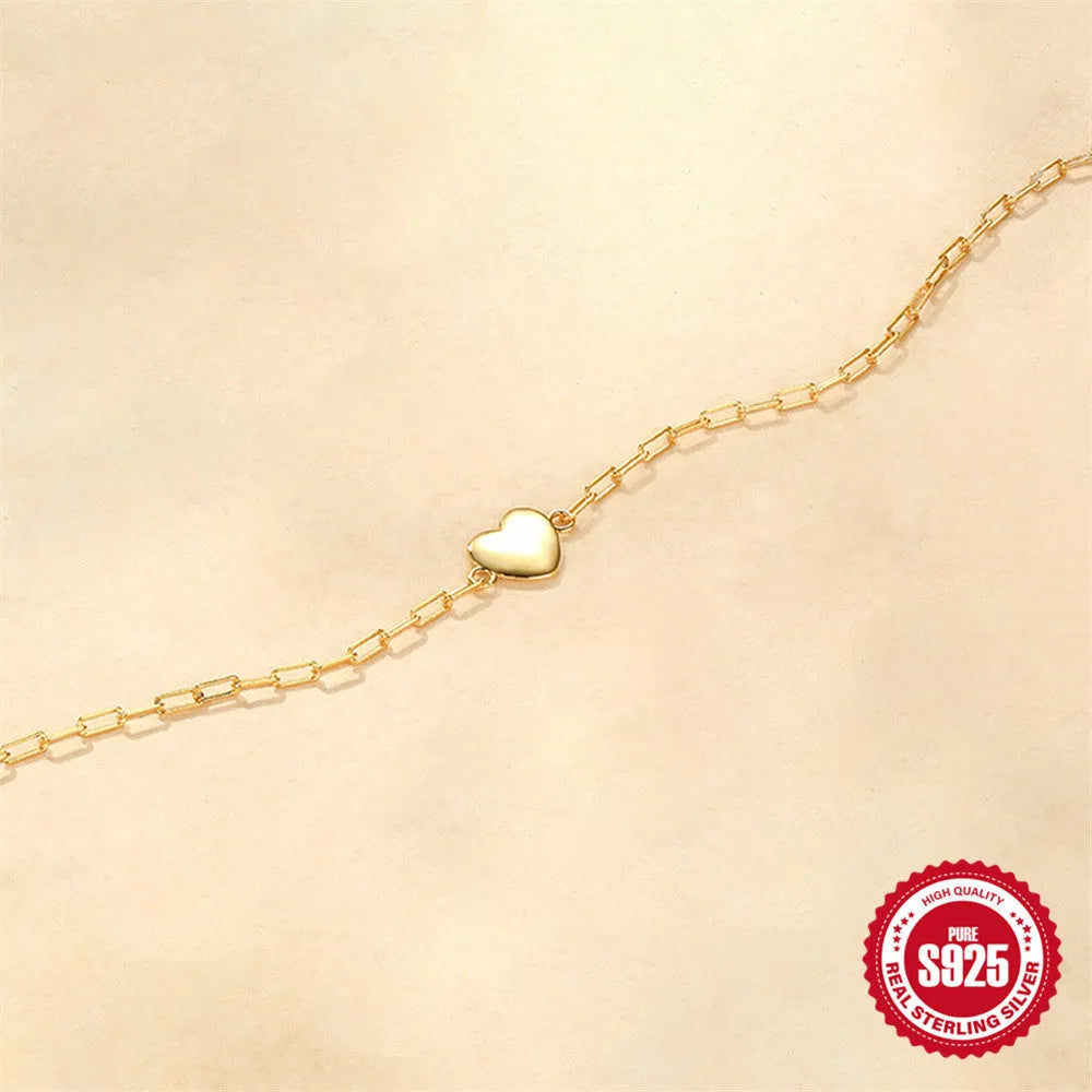 Gold tone S925 sterling silver bracelet with glossy heart charm and clip chain fastening