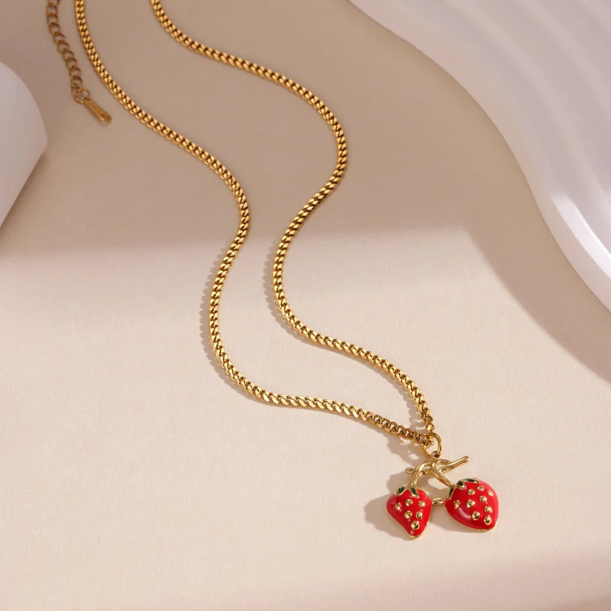 Women's strawberry-shaped alloy pendant necklace on a stainless steel chain in red or white powder gradient colour.