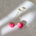 A pair of peach-shaped acrylic earrings on copper posts, shown in small and large size variants.