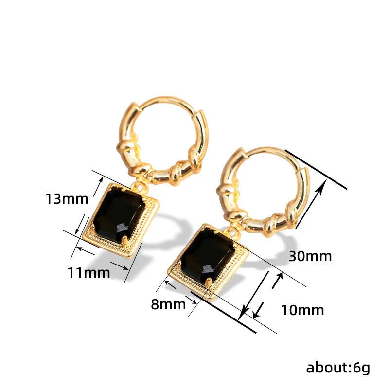 A pair of geometric copper earrings with black zircon stones in a quadrilateral shape.