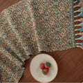 Nordic jacquard table runner with tassel fringe in dark blue with striped pattern on wooden table