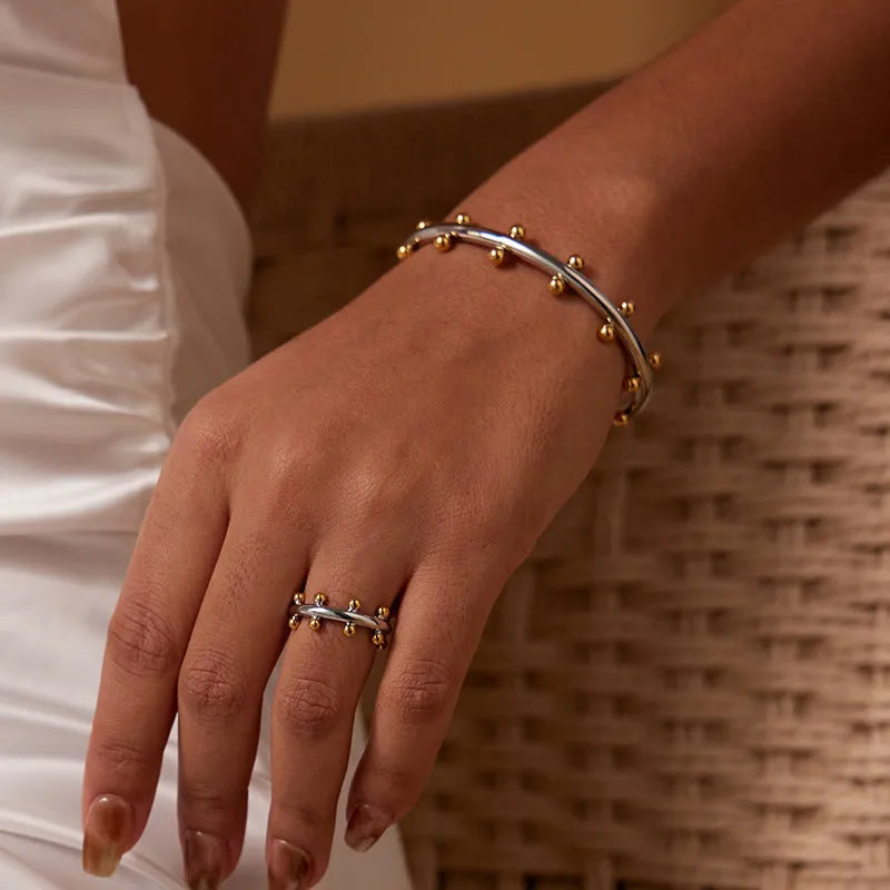 Close-up of stainless steel C-shaped textured bean beads in gold, steel, and steel-gold colours.