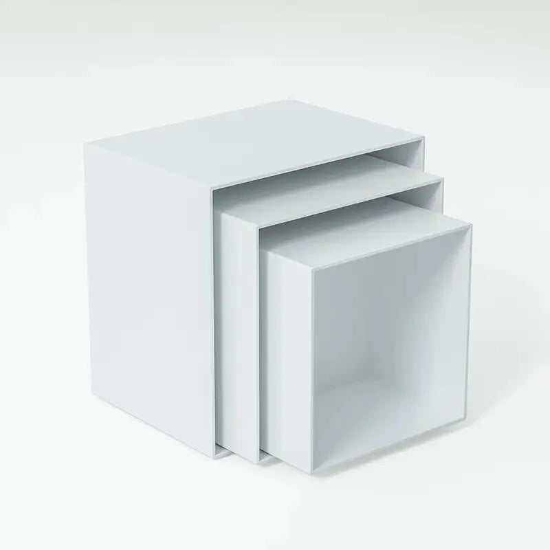 White and transparent plastic cube dessert display stands arranged in a tiered set.