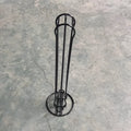 A black wrought iron coffee capsule storage rack holding pods on a kitchen counter.