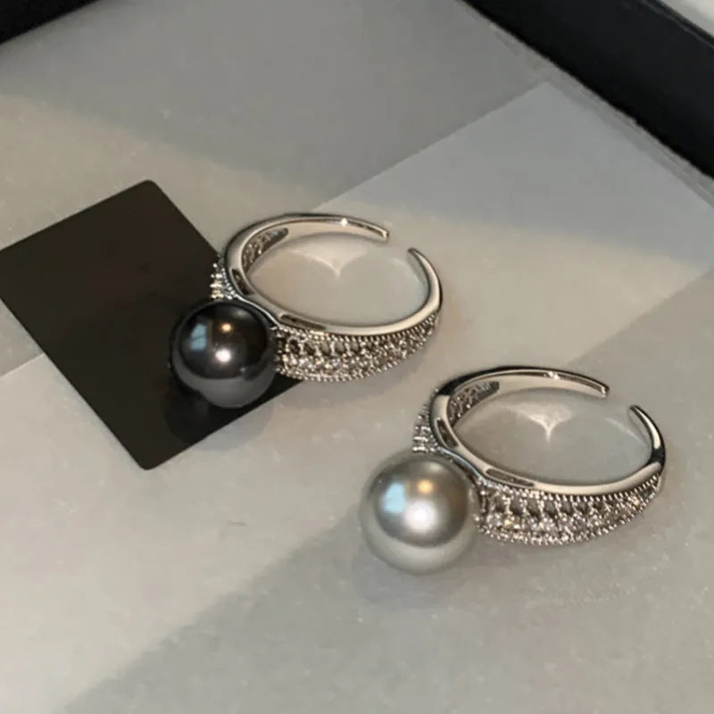 Open finger ring with geometric design, black pearl accent, and adjustable copper band