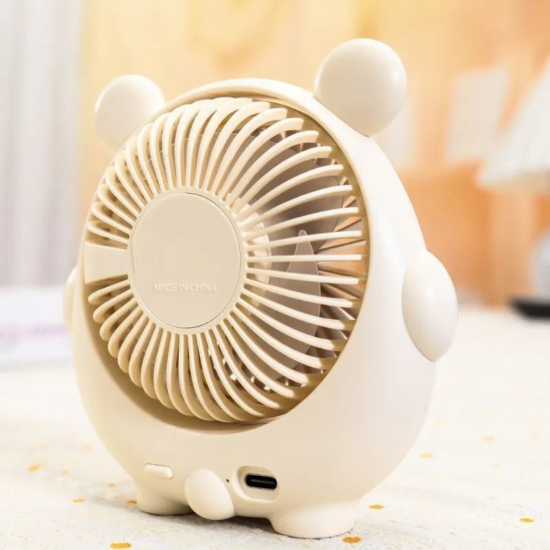 Cute dog-themed desktop electric fan with USB cable and multiple colour options on a desk.