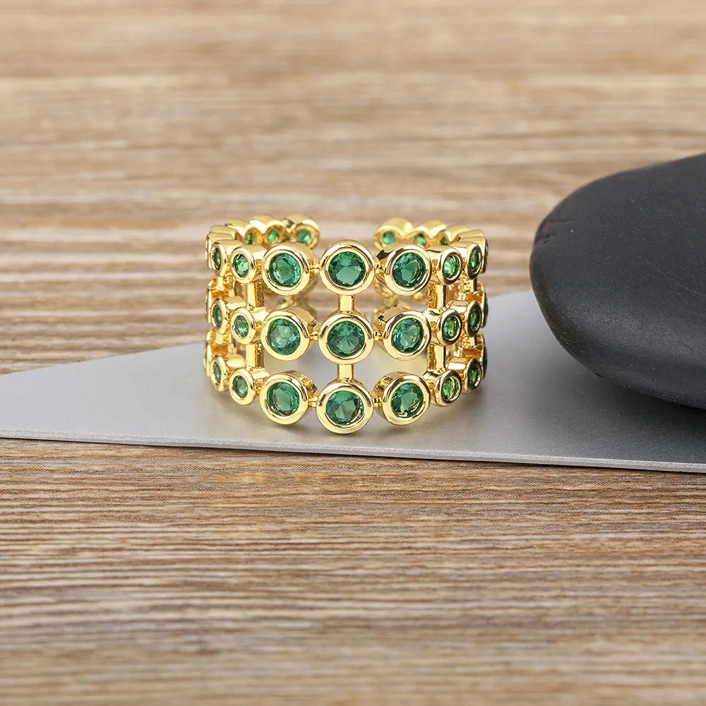 Three-layer wide band statement ring with green zircon stones and gold plating on copper base