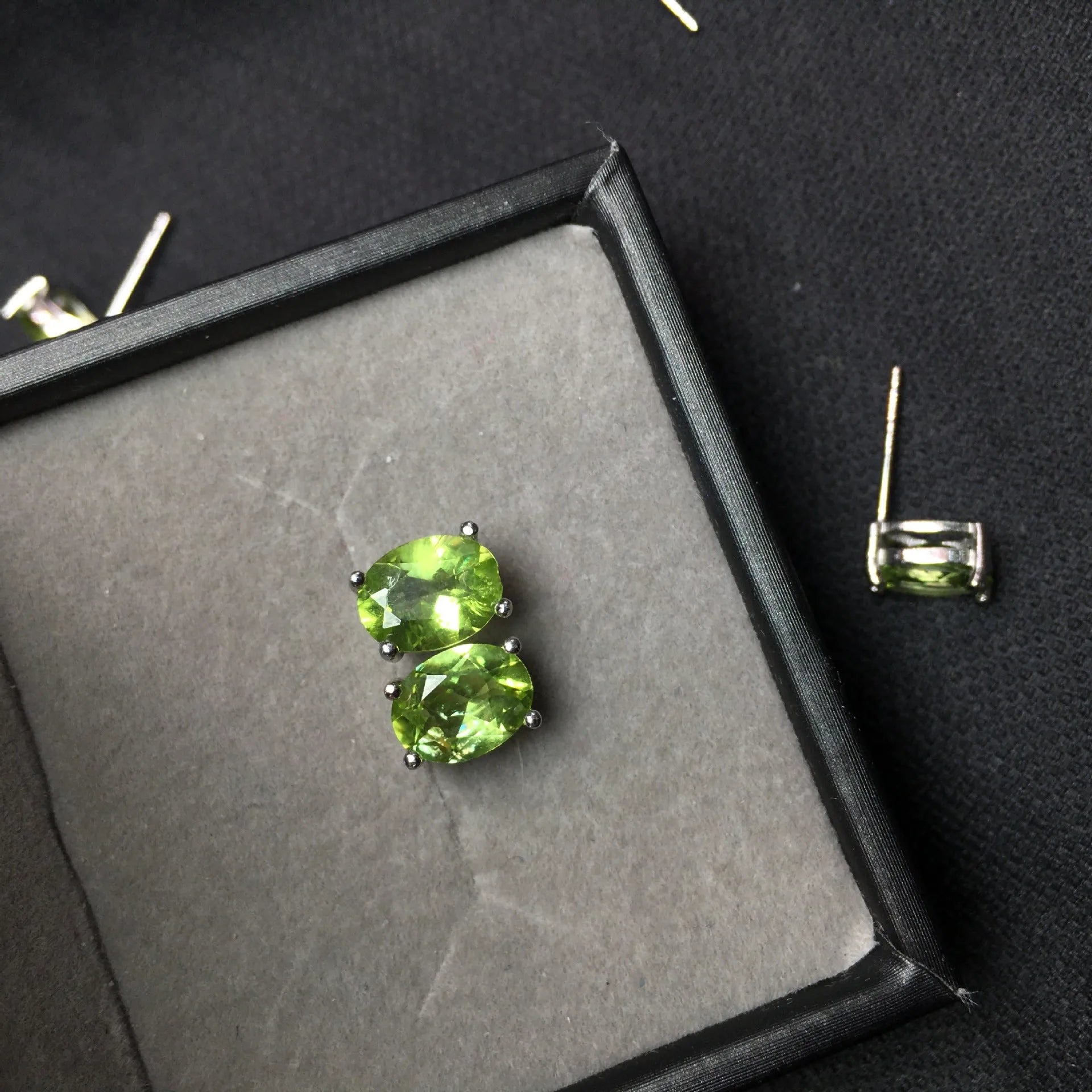 Grass green natural olivine oval stud earrings in sterling silver on a white background.