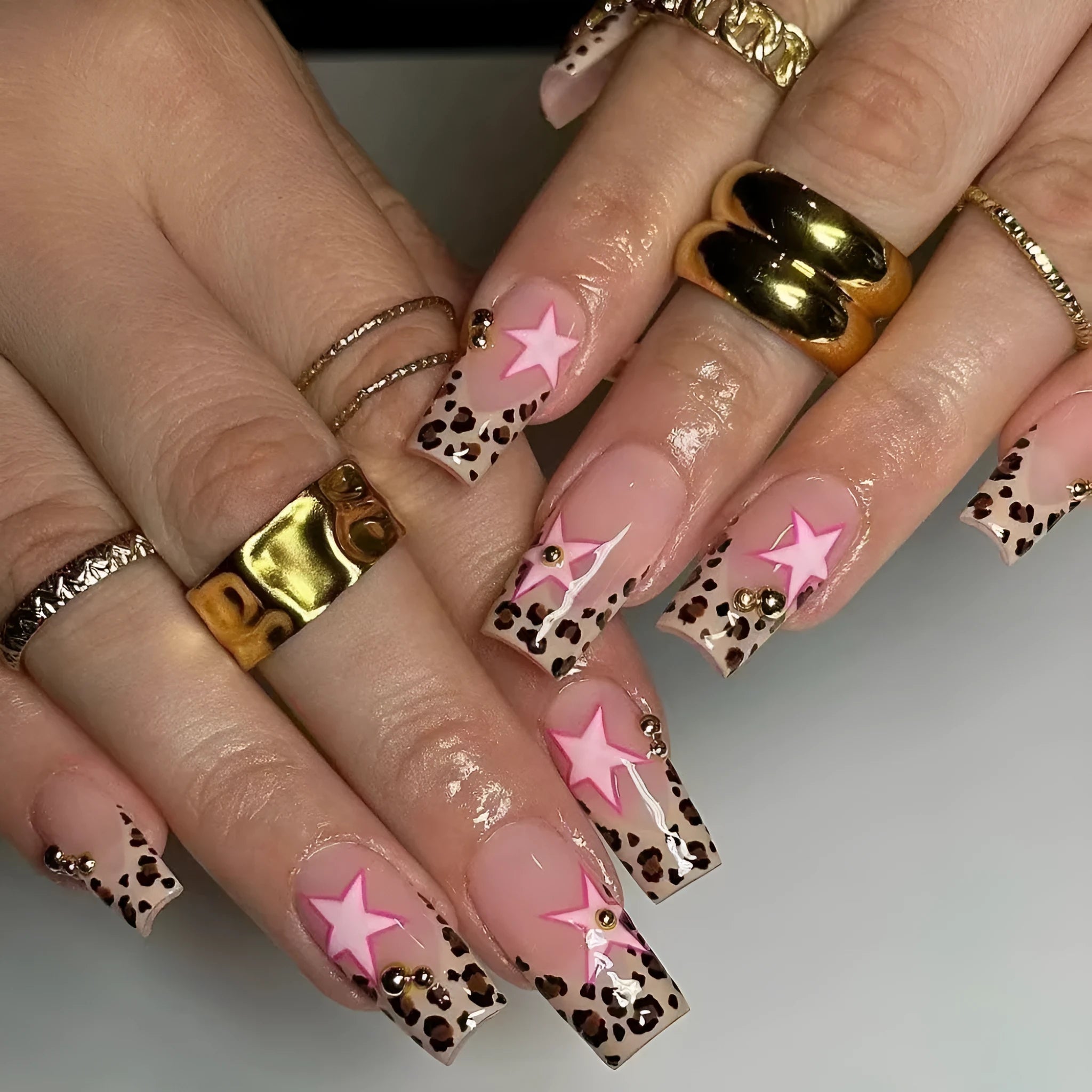 French leopard print nail art with five-pointed stars, pearl and diamond accents on wearable nail pieces