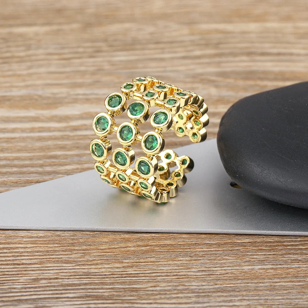 Three-layer wide band statement ring with green zircon stones and gold plating on copper base