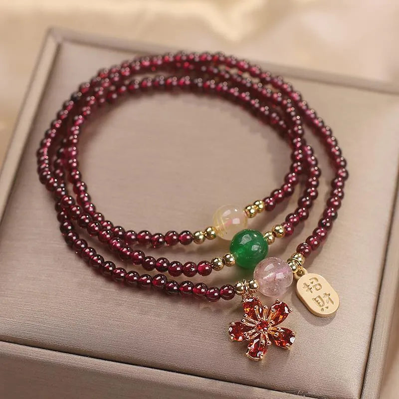 Women's simple bracelet made of red crystal with sequin accents on a wrist.