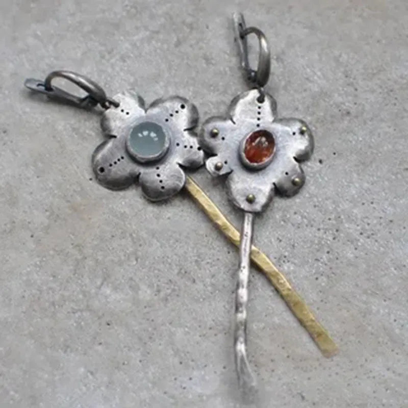 A pair of long retro earrings with asymmetric geometric flower shapes in a two-tone electroplated finish.
