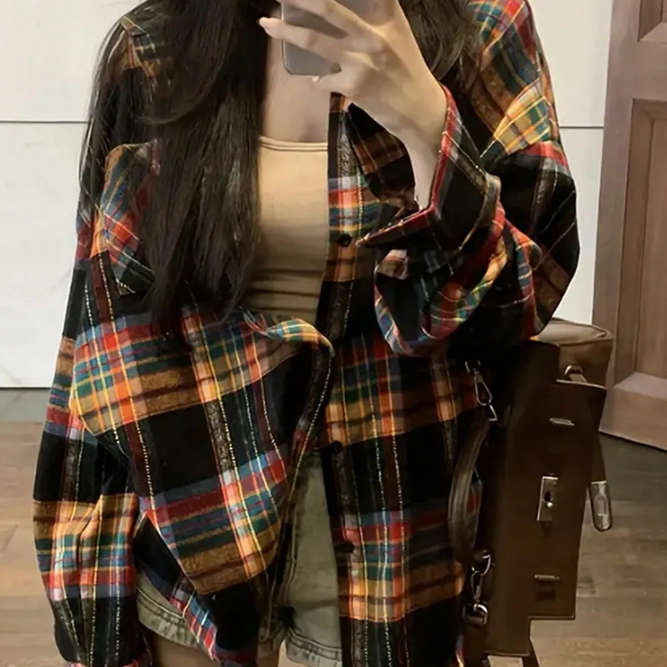A woman's loose fit cotton plaid shirt in a retro style, shown in a choice of black, green, or purple colours.