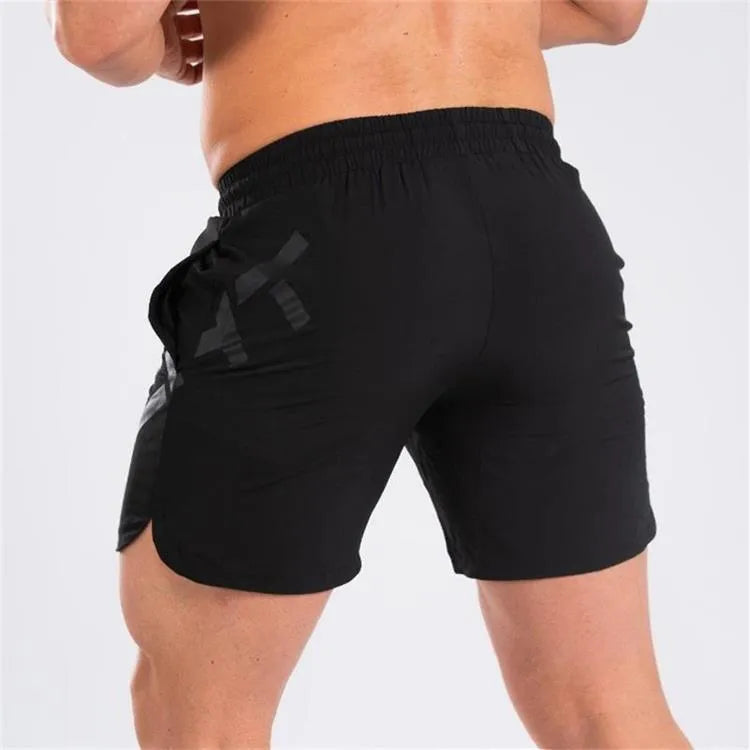 Men's black quick-drying nylon blend training shorts with elastic waist, shown in knee-length sports style.