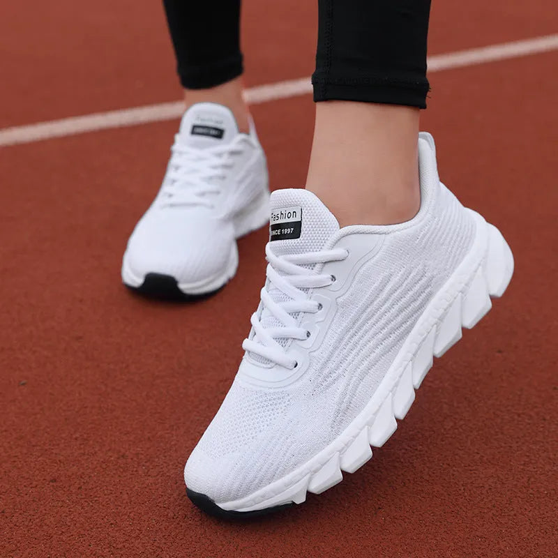 Women's black and white running shoes with cross strap detail and MD shock absorption sole