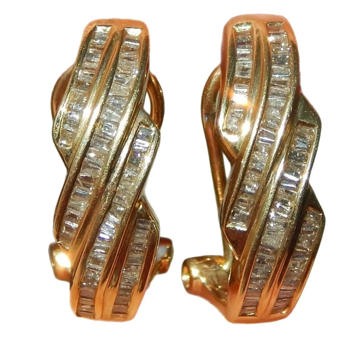 A pair of gold-coloured geometric round earrings made from copper on a plain background.