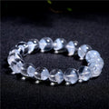 Women's white crystal pyramid bead ghost bracelet with a Ruyi charm on a white background.