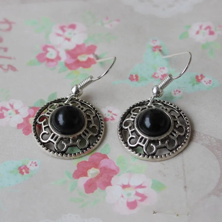 Handmade Miao ethnic style silver earrings with a blue turquoise flower disk and geometric patterns.