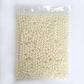 Clear acrylic makeup brush holder on a countertop with pearl coloured beads inside, measuring 12.3x10.6x21.5cm