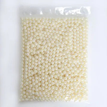 Clear acrylic makeup brush holder on a countertop with pearl coloured beads inside, measuring 12.3x10.6x21.5cm