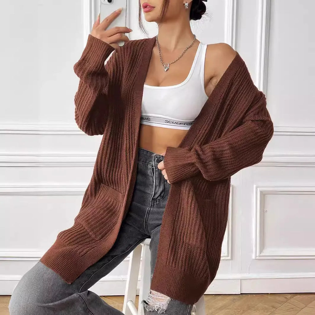 Women's dark green loose fit cardigan with two front pockets and long sleeves.