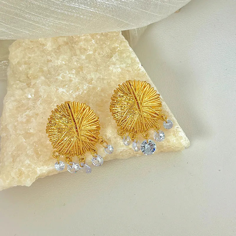 Geometric gold metal hoop earrings with round design elements