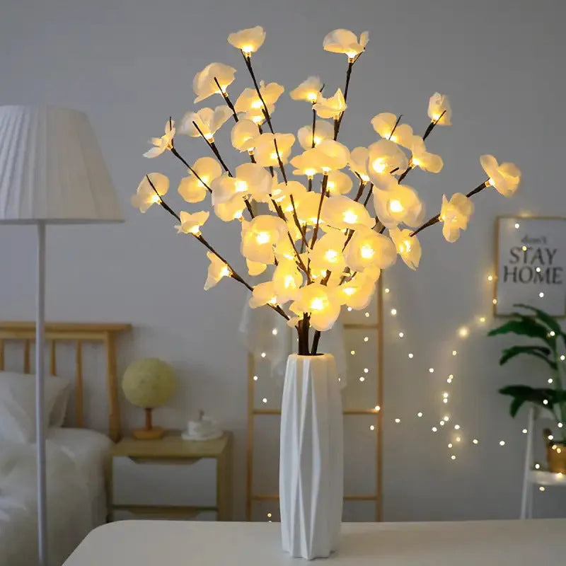Pink LED phalaenopsis orchid branch decorative light on a table, 65 cm long with fabric leaves.
