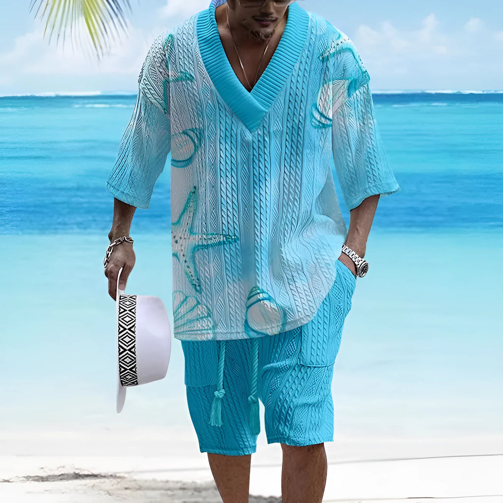 Man wearing a loose fit casual short sleeve suit with matching shorts in a light colour.