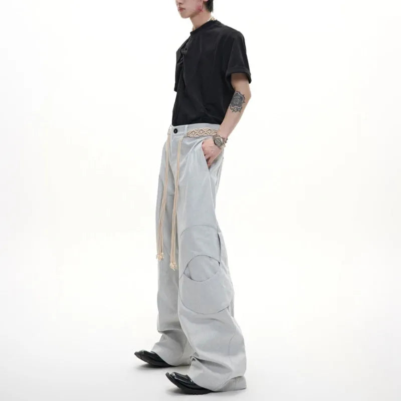 Men's dark blue straight-leg cotton jeans with heavy stitching on the belt and tassel pocket details.