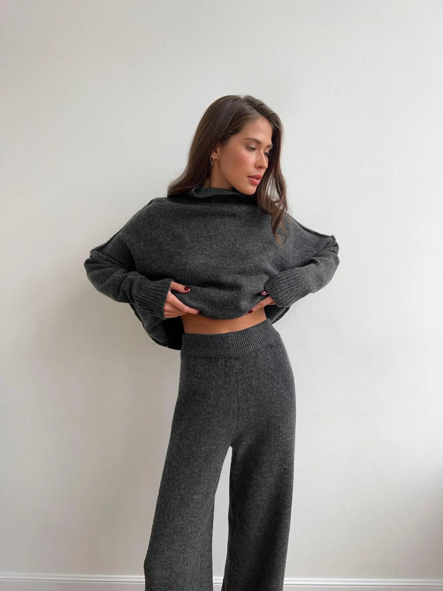 Women's dark grey acrylic suit featuring a side-slit sweater with matching full-length trousers.