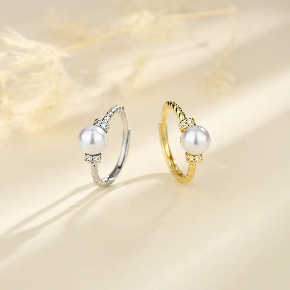 Adjustable copper ring with antique twist design and inlaid pearl in gold finish.