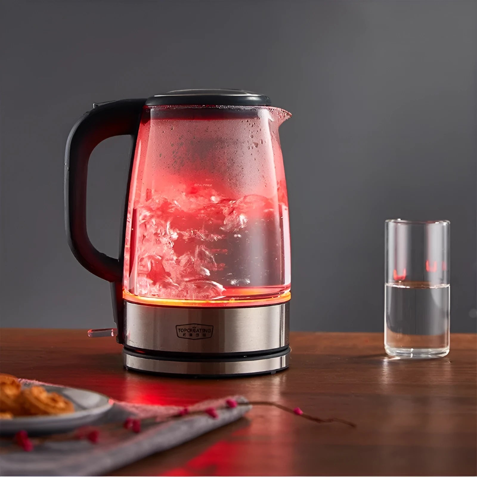 Transparent glass electric kettle with 1.7L capacity, scale window, black base and handle, and power cord on white background