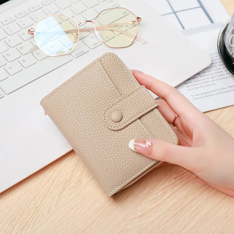 A ladies' short folded wallet with a lychee pattern, shown in beige, pink, black, and red colour options.