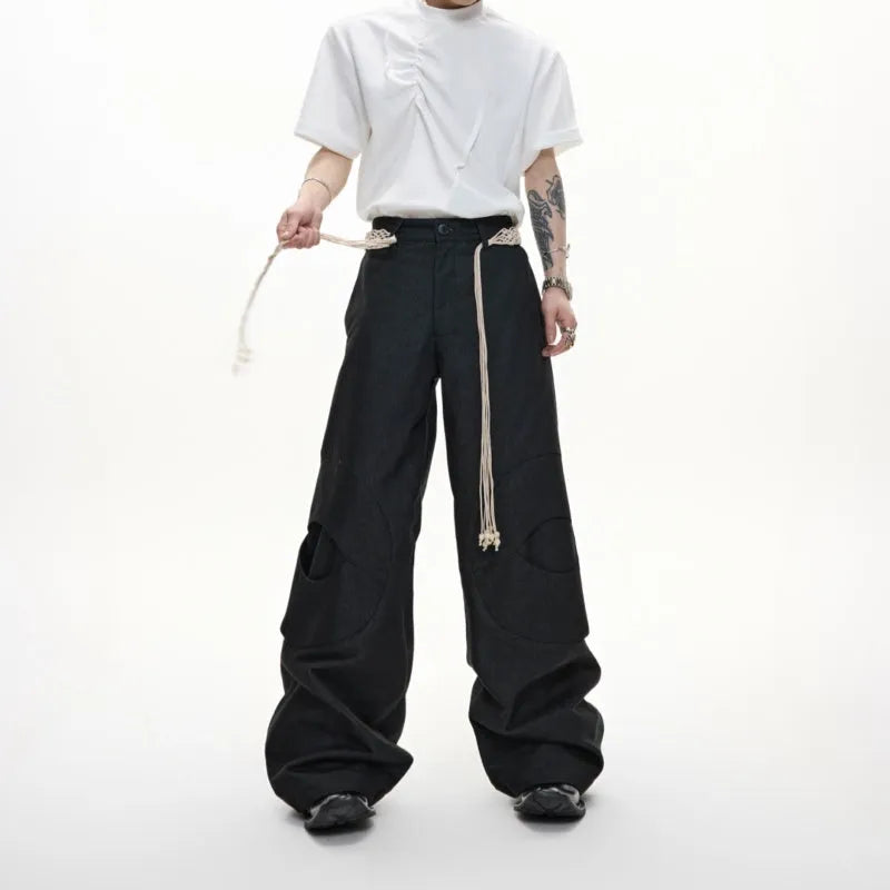 Men's dark blue straight-leg cotton jeans with heavy stitching on the belt and tassel pocket details.