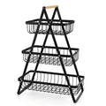 Black detachable double-layer iron fruit basket with a wooden carry handle on a tabletop.