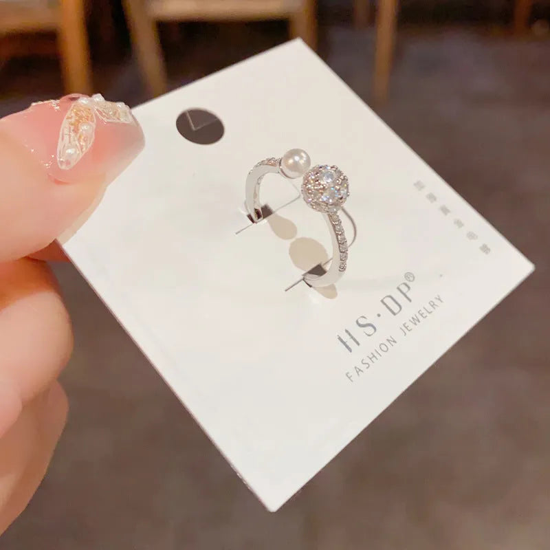 Open-end pearl ring with round zircon stone in gold or silver with geometric shape