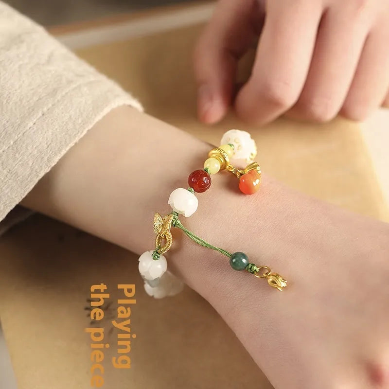 White jade Bodhi bracelet with lotus beads and a large pumpkin bead on an open rope.