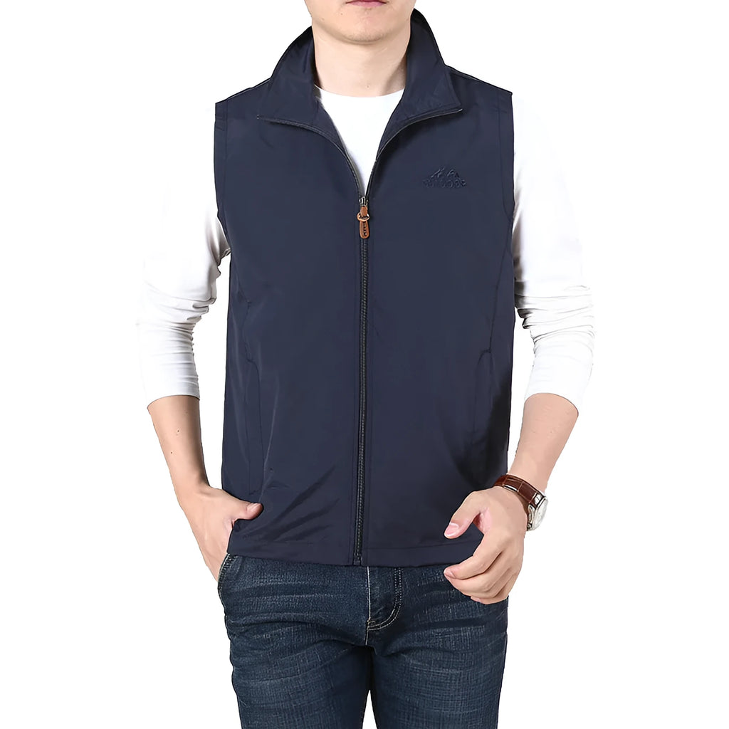 Man wearing a khaki casual waistcoat with side pockets over a blue shirt.