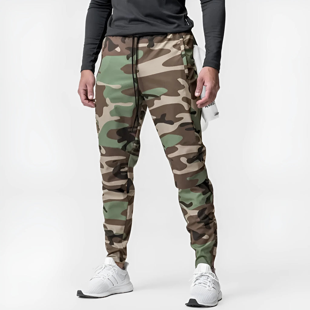 Men's loose grey running pants with ankle ties, laid flat to show mid-waist and full-length design.
