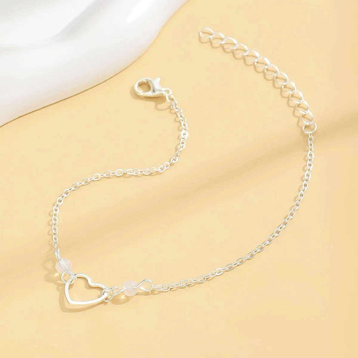 Adjustable women's anklet with heart pendant in gold or silver alloy