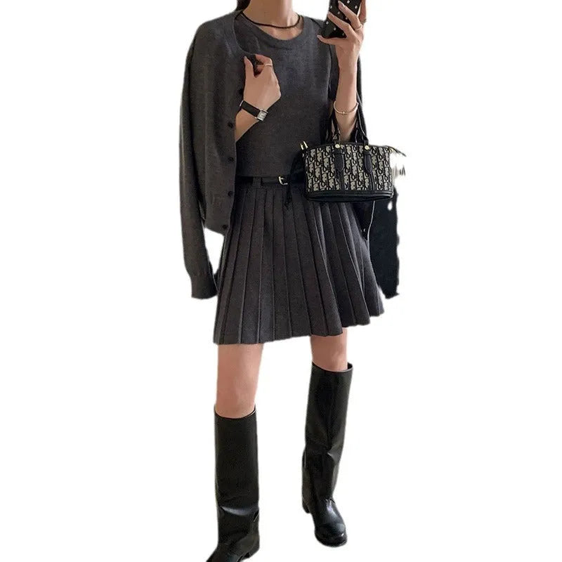 Women's grey art retro knitted vest skirt and long sleeve cardigan two-piece set on a hanger.