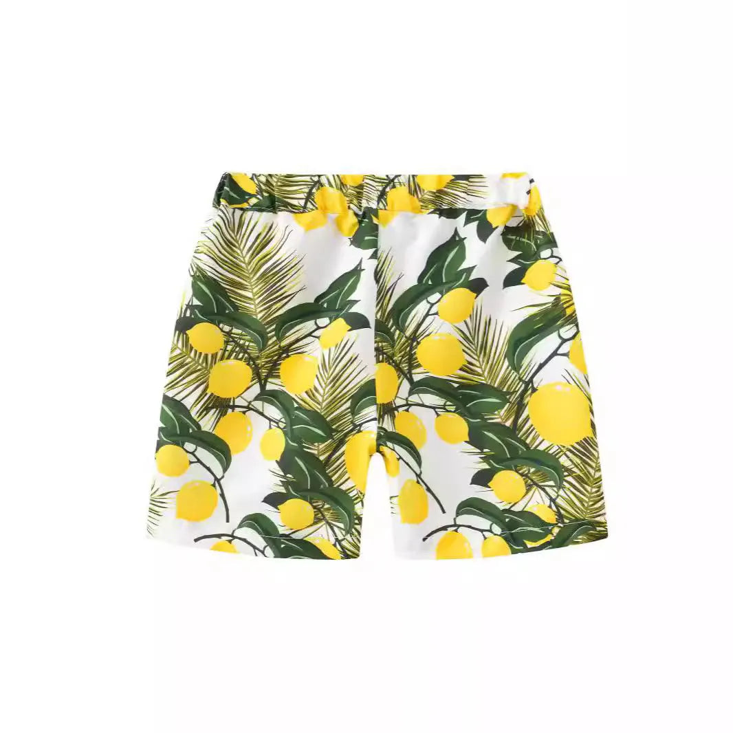 Colourful printed beach shorts on a hanger showing coconut tree and dinosaur designs.
