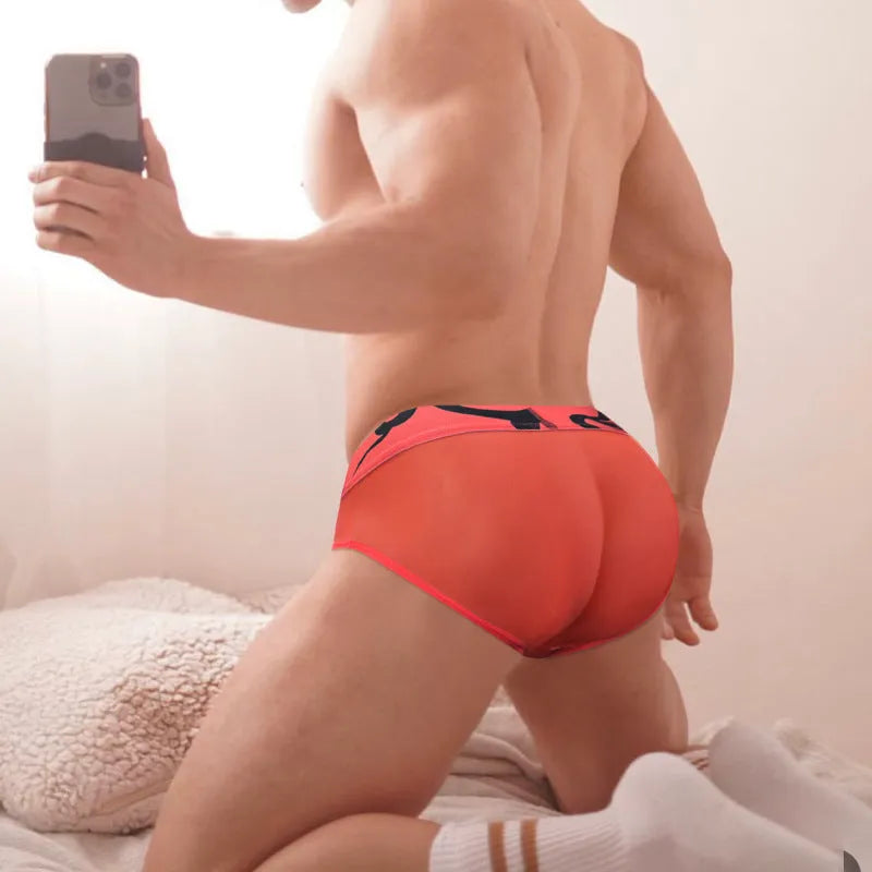 Men's solid colour cotton boxer shorts on a low waist, shown in black, pink, and red.