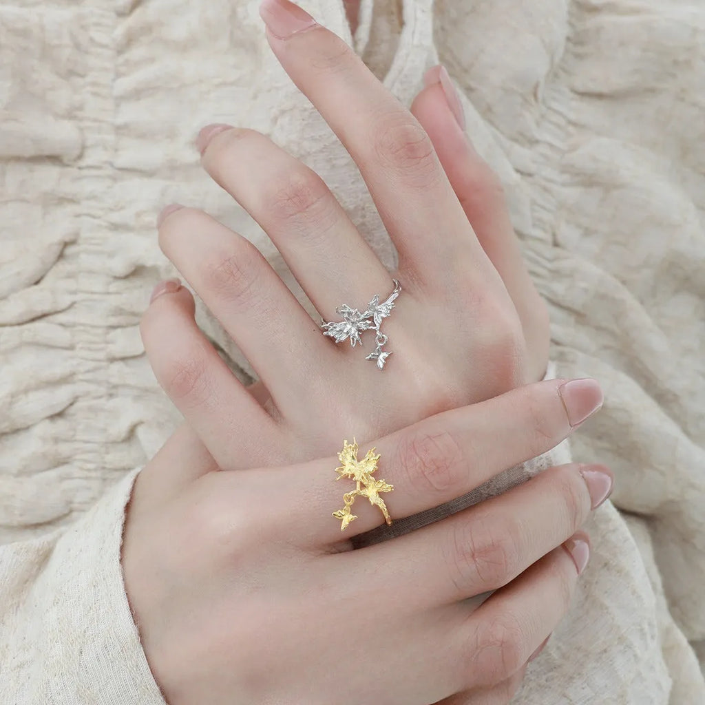 Silver butterfly ring with adjustable opening in white gold or gold finish.