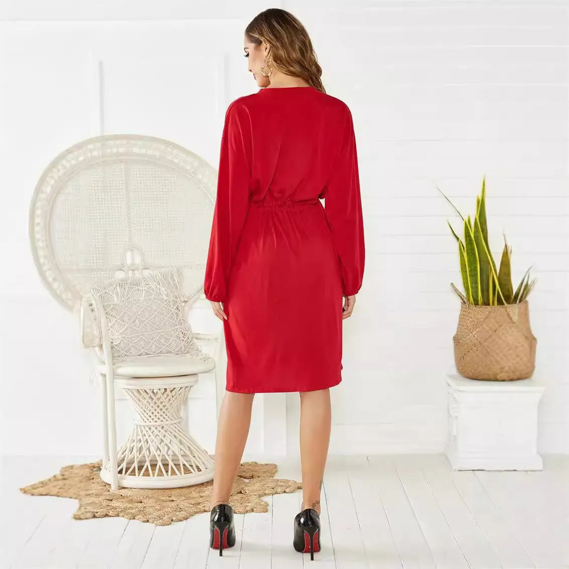 A women's loose black A-line dress with long sleeves, an elastic waist, and a cinched belt on a mannequin.