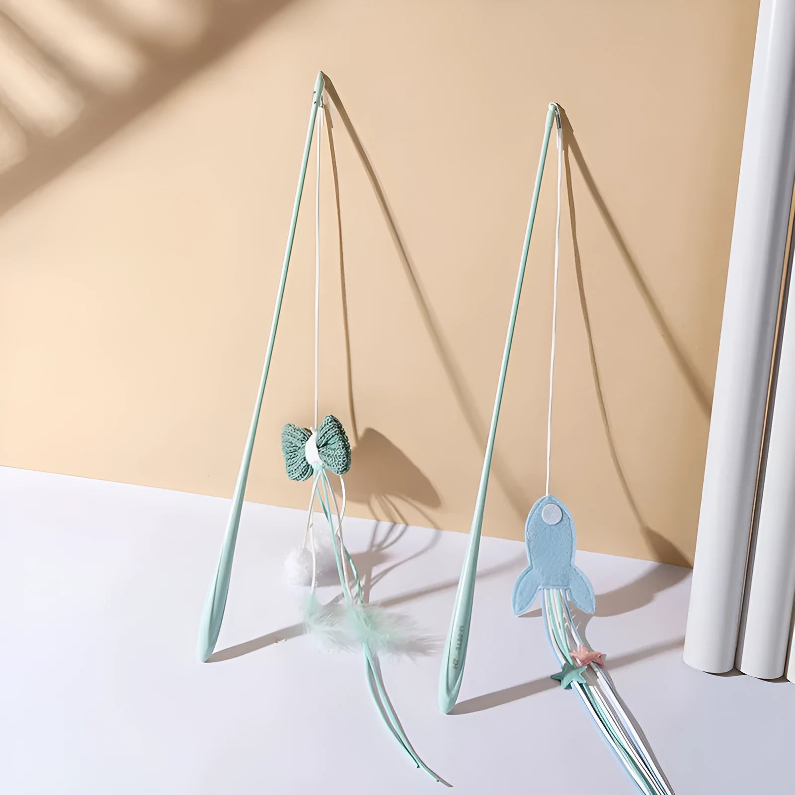 Blue rocket cat teaser toy with feathers on long pole for interactive play with kittens and cats