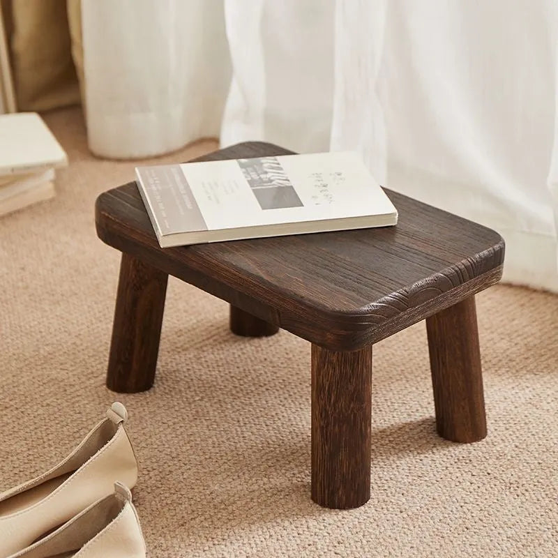 Solid wood household changing stool with distressed finish and bracket structure legs.