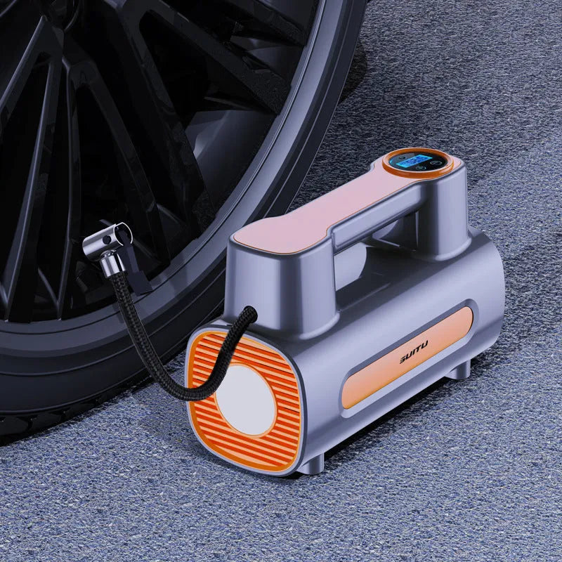 Black portable wireless tire inflator with digital display and USB charging cable on a grey background.