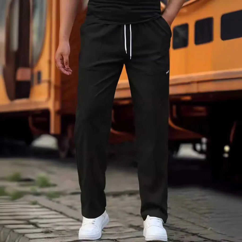 Men's light grey polyester trousers for spring and autumn wear, laid flat.